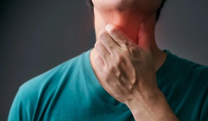 Mann fasst sich an Hals Heiserkeit und Husten belasten
