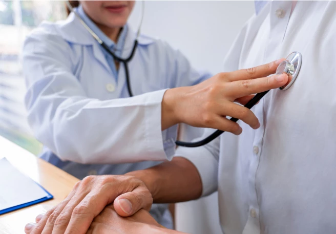 Untersuchung der Lunge Eine Ärztin hört den Brustkorb eines Patienten mit einem Stethoskop ab